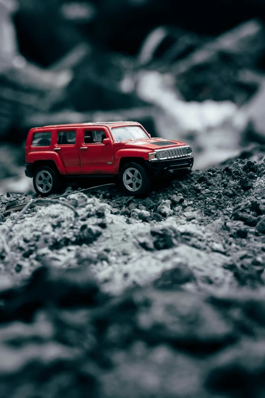 a toy jeep sitting on top of a pile of rocks, a tilt shift photo, pexels contest winner, photorealism, red car, cybertruck, next to a waterfall, ilustration
