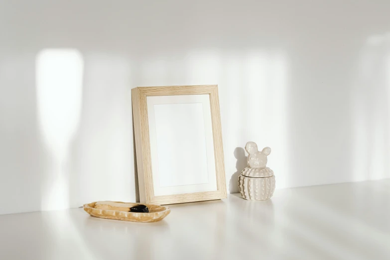 a picture frame sitting on top of a white table, pexels contest winner, wooden bowl, miniature product photo, white room, a blond