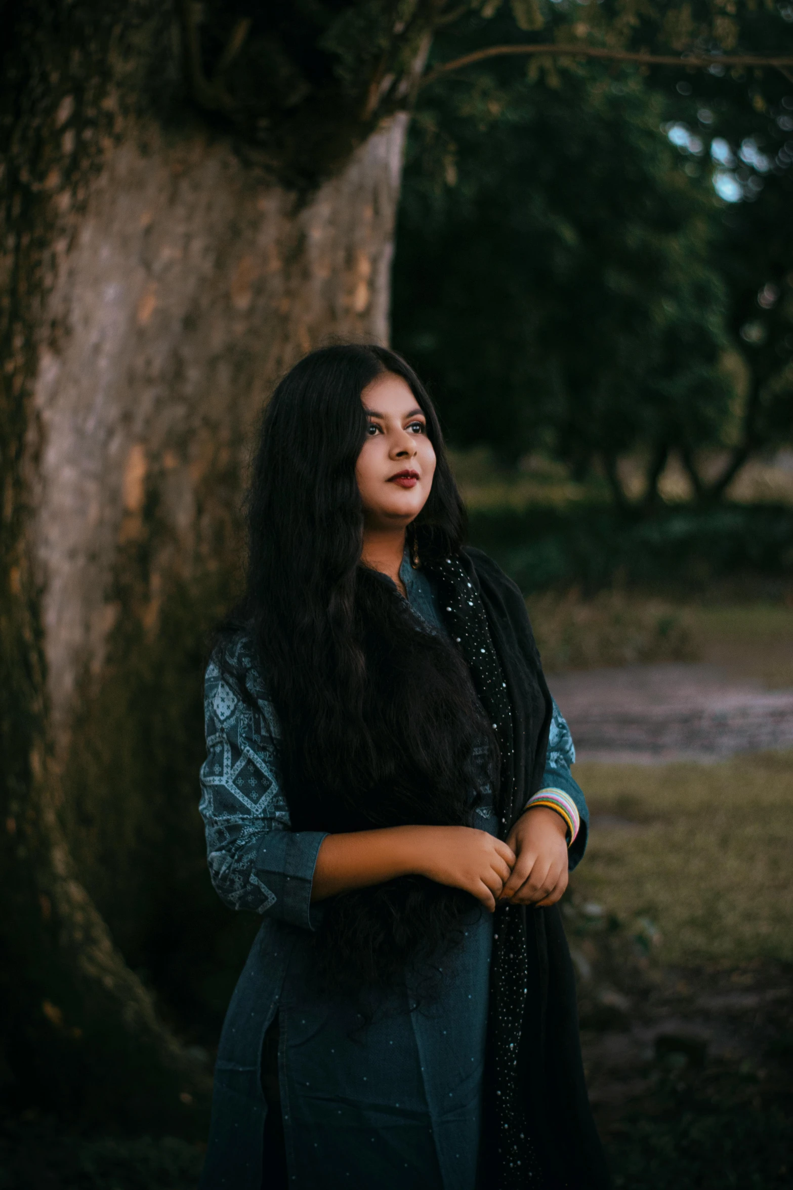 a woman standing in front of a tree, an album cover, by Riza Abbasi, pexels contest winner, long hair shawl, assamese, ((portrait)), wearing casual clothing