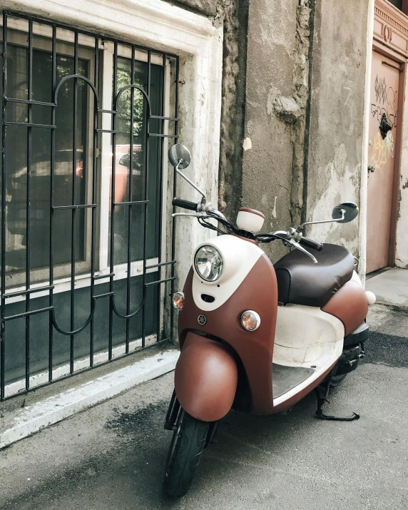 a motor scooter parked in front of a building, brown and cream color scheme, thumbnail, cute photo, looking around a corner
