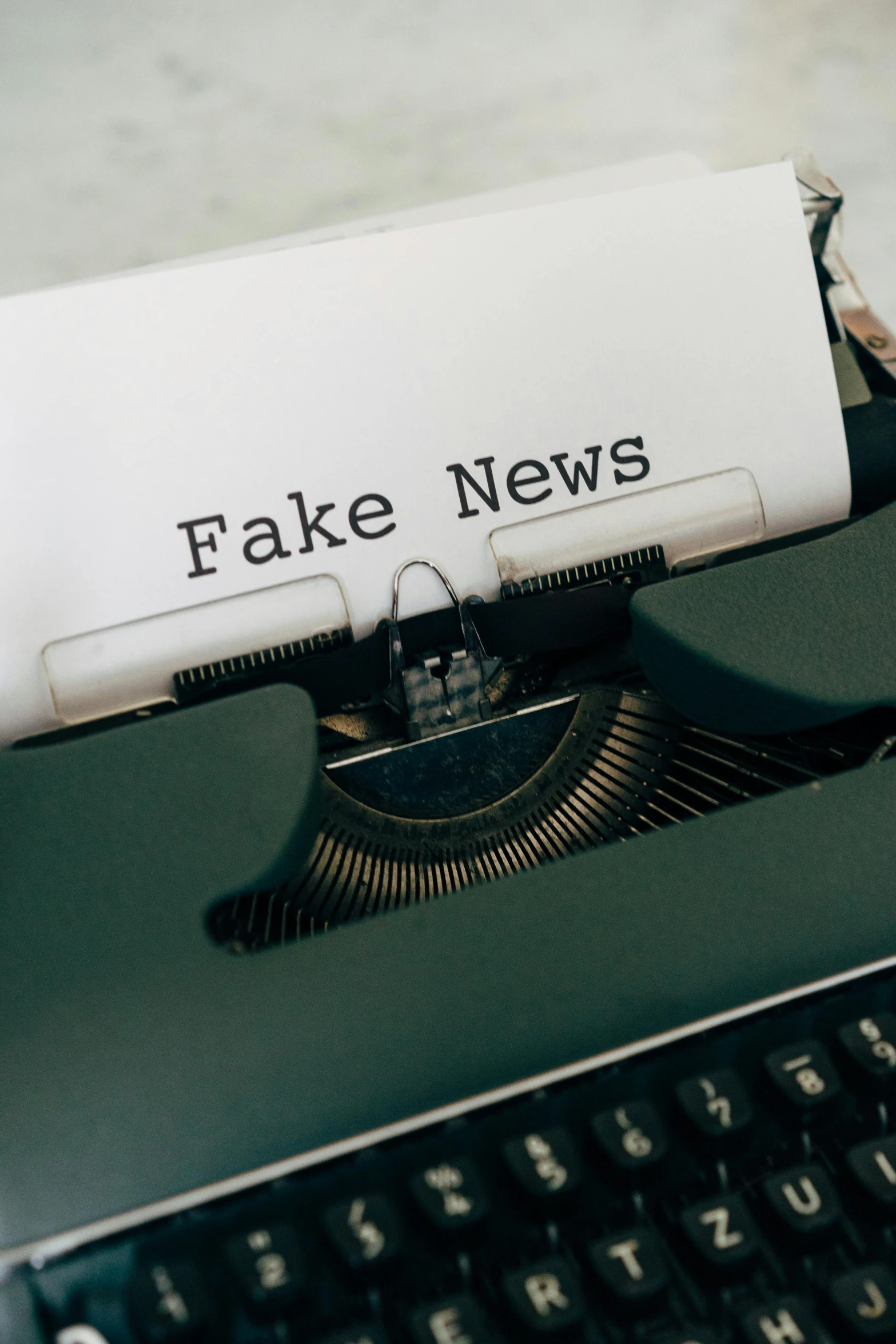 an old typewriter with fake news written on it, by Claire Falkenstein, trending on pexels, private press, paul barson, foil, instagram story, censored