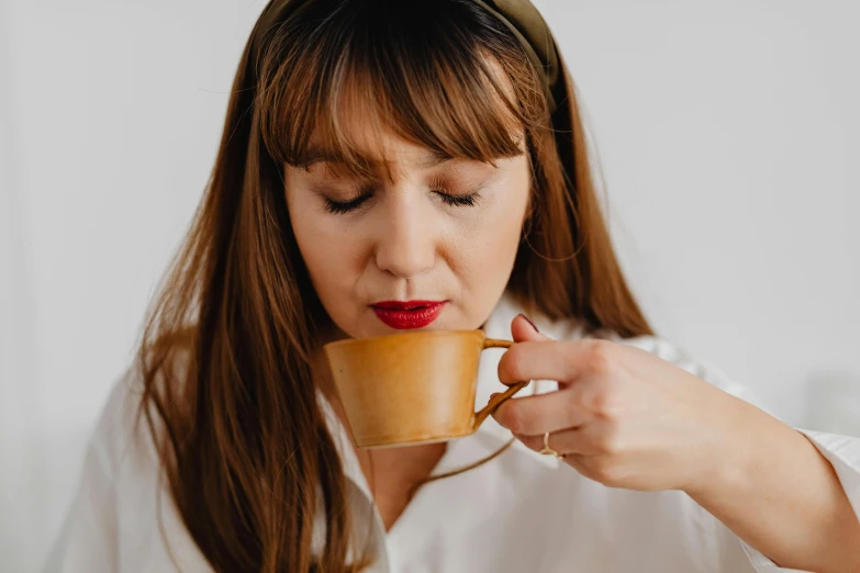 a woman is drinking a cup of coffee, by Emma Andijewska, trending on pexels, renaissance, avatar image, thick jawline, aussie baristas, set against a white background