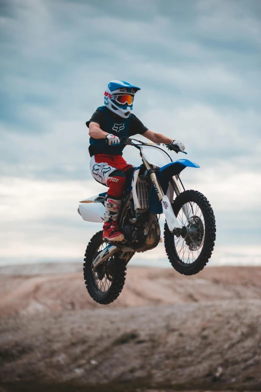 a man flying through the air while riding a dirt bike, pexels contest winner, figuration libre, sassy pose, blue, kids, instagram story