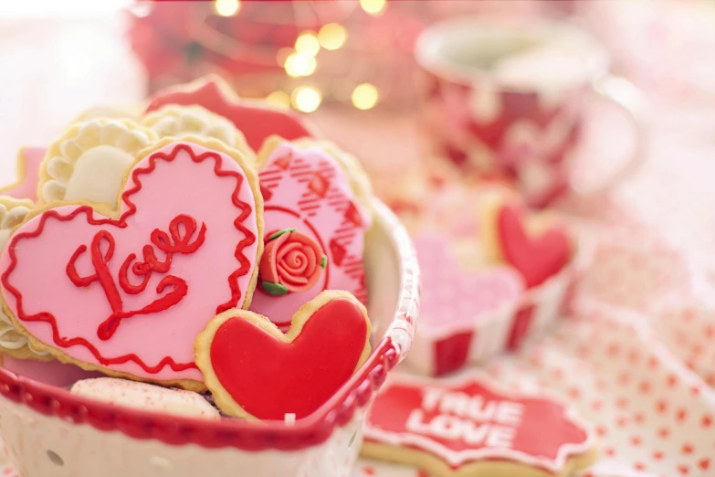 a close up of a bowl of cookies on a table, by Sylvia Wishart, pexels, romanticism, pink and red color style, hearts, thumbnail, holiday