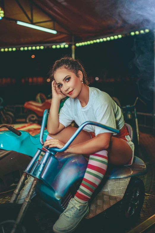 a woman sitting on top of a blue motorcycle, teenage vanessa morgan, bumper cars, profile image, promotional image