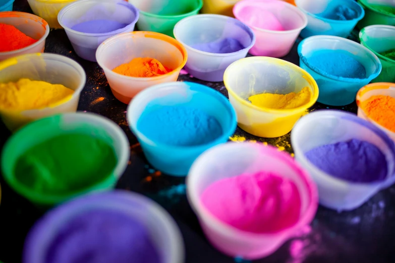 a table topped with lots of different colored paint, chalk art, trending on unsplash, boiling imagination in a bowl, sterile colours, pastel colourful 3 d, vibrant powder paints