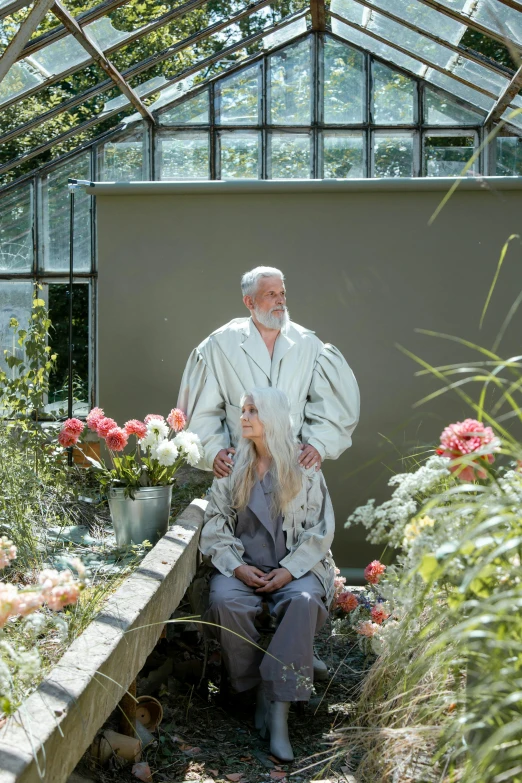a man and a woman sitting in a greenhouse, inspired by Petrus Van der Velden, unsplash, renaissance, silver hair and beard, bathrobe, large tall, 2010s
