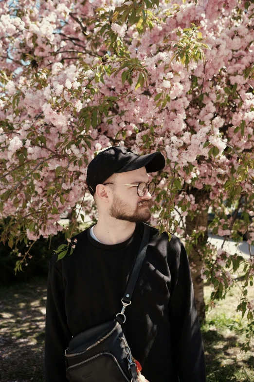 a man standing in front of a flowering tree, an album cover, by Anato Finnstark, unsplash, headshot profile picture, snacks, smooth pale skin, smol