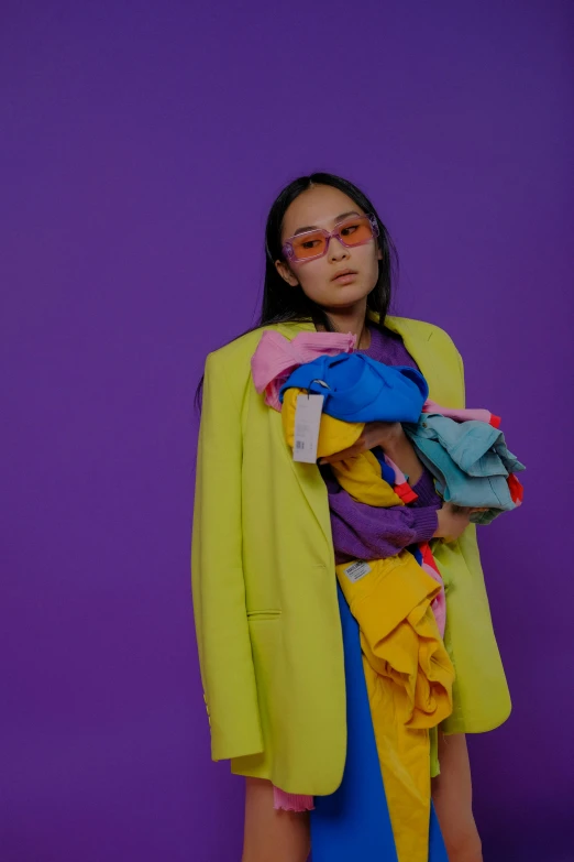 a woman standing in front of a purple wall, an album cover, inspired by Wang E, color field, with yellow cloths, full of things, mei-ling zhou, a purple suit jacket