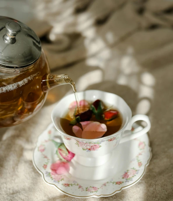 a tea pot sitting on top of a table next to a cup of tea, pexels, white and pink cloth, thumbnail, soup, opening shot