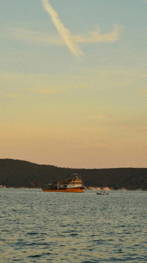 a boat floating on top of a large body of water, happening, evening, mustard, manly, raw file