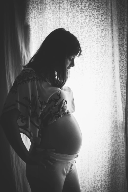 a pregnant woman standing in front of a window, a black and white photo, by Felix-Kelly, pexels contest winner, beautiful backlit, mother, instagram picture, :: morning