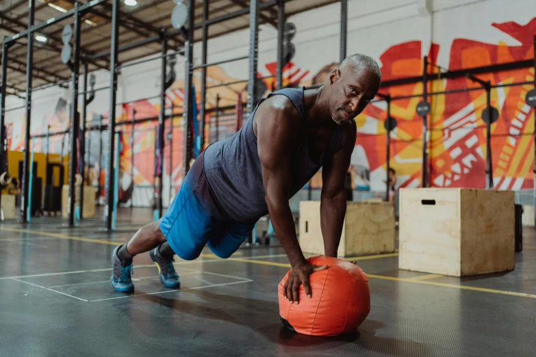 a man doing push ups on an orange ball, a photo, pexels contest winner, shaq, local gym, aged 4 0, profile image