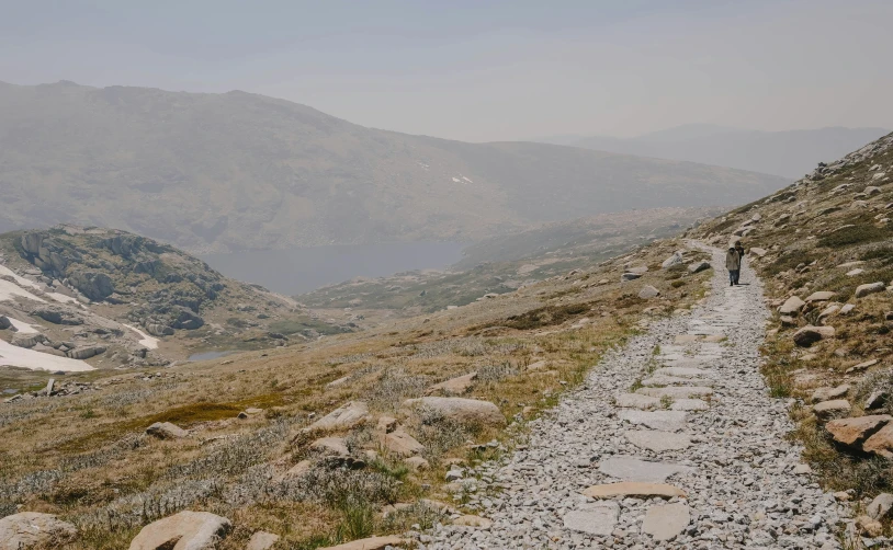 a person walking up a rocky path in the mountains, pexels contest winner, norwegian landscape, background image, gravel and scree ground, whistler