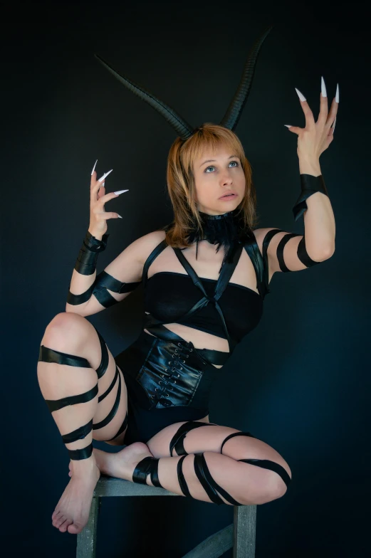 a woman sitting on top of a wooden chair, inspired by Ai-Mitsu, trending on deviantart, renaissance, leather bunny costume bodysuit, cosplay photo, long spider paws, with arms up