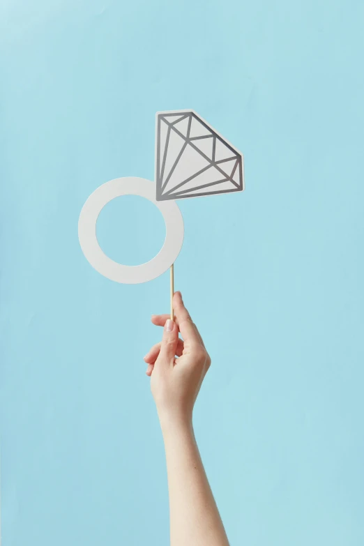 a person holding a paper diamond on a stick, rings, photo booth, how-to, on clear background