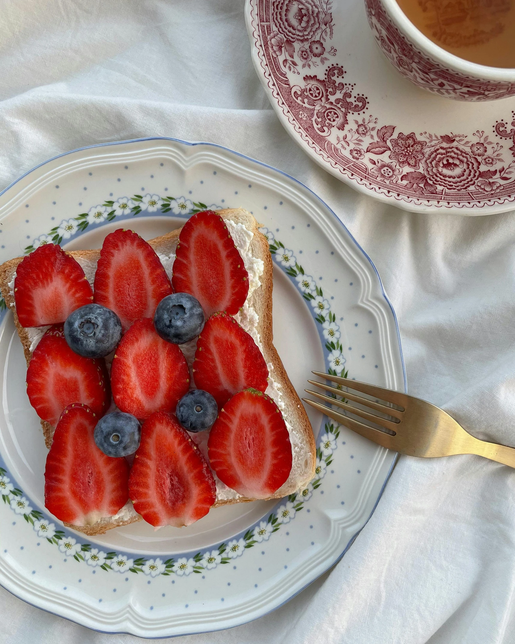 a plate topped with strawberries and blueberries next to a cup of coffee, inspired by Richmond Barthé, unsplash, hurufiyya, gucci bread, vintage photo, background image