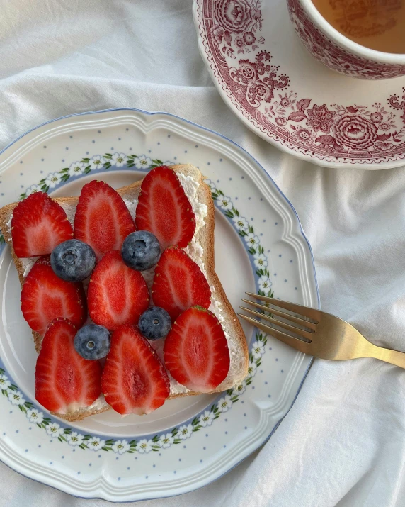 a plate topped with strawberries and blueberries next to a cup of coffee, inspired by Richmond Barthé, unsplash, hurufiyya, gucci bread, vintage photo, background image