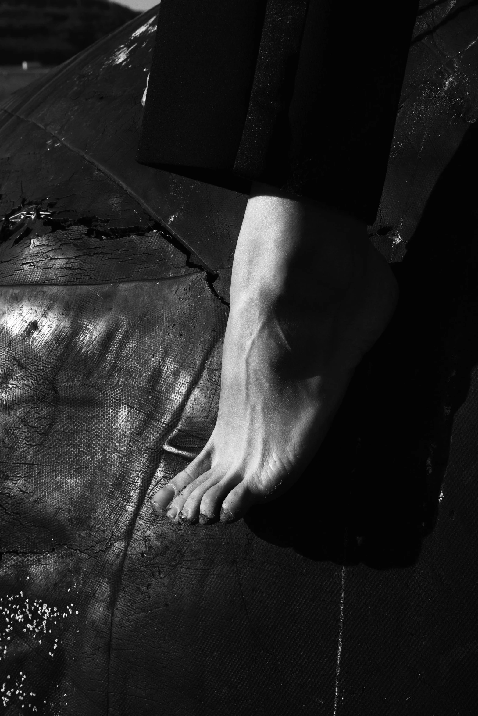 a black and white photo of a person standing on a surfboard, a black and white photo, inspired by Victorine Foot, unsplash, hyperrealism, feet on the ground, yohji yamamoto, skin wounds, ignant