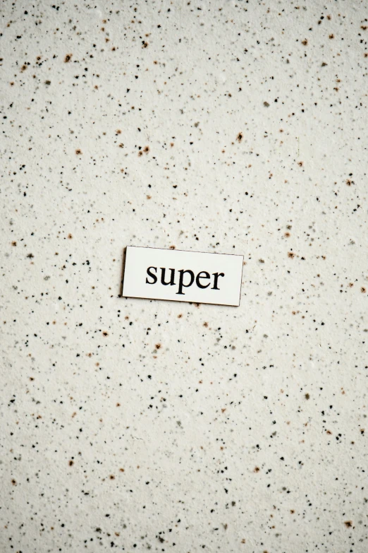 a piece of paper with the word super written on it, trending on pexels, superflat, speckled, nadav kander, tumblr aesthetic, stone