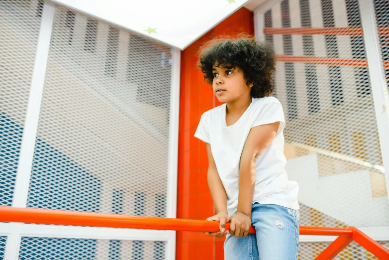 a little girl that is standing on a rail, pexels contest winner, ashcan school, white and orange, afro tech, handsome girl, stood in a cell