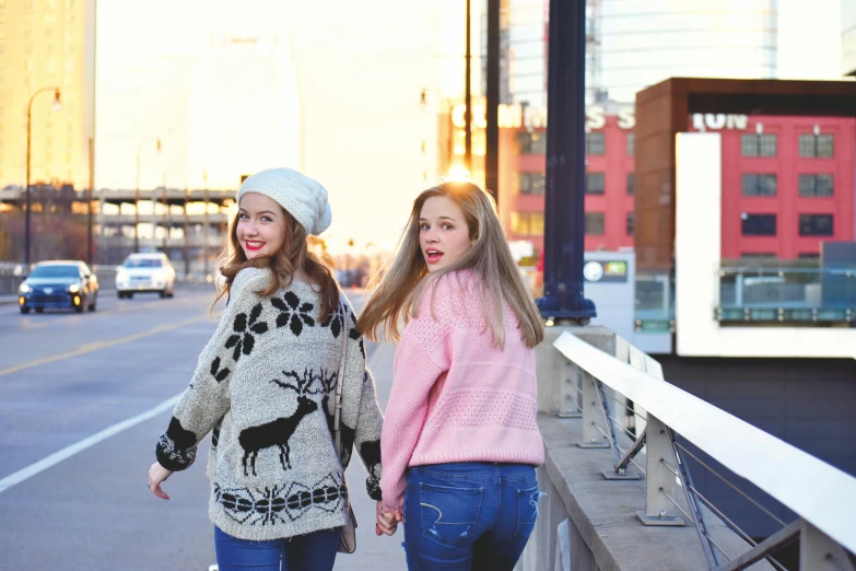 two girls walking down a street holding hands, trending on pexels, realism, wearing sweater, sadie sink, photoshoot for skincare brand, on a bridge