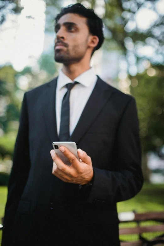 a man in a suit holding a cell phone, pexels contest winner, renaissance, in a city park, corporate phone app icon, black suit, outdoor