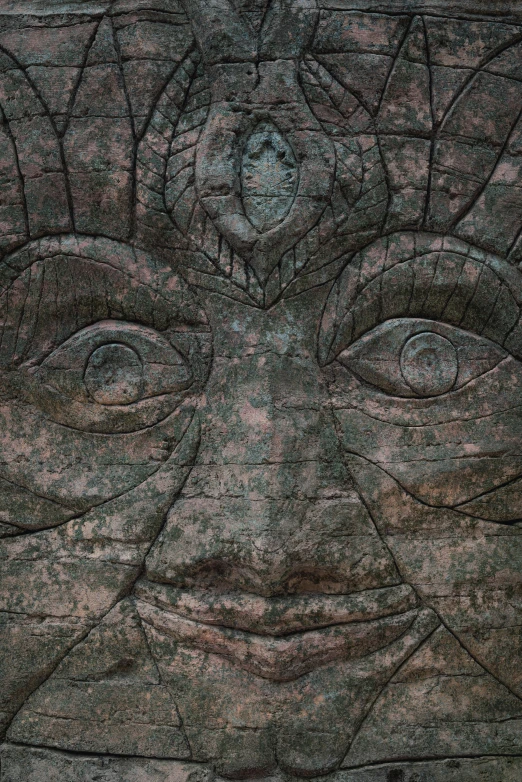 a close up of a stone face on a wall, an album cover, inspired by Sir Jacob Epstein, trending on zbrush central, all - seeing eye, angkor, wood carving, shipibo