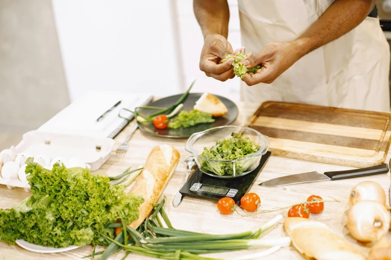 a person in a kitchen preparing food on a table, lush greens, profile image, daily specials, unbeatable quality