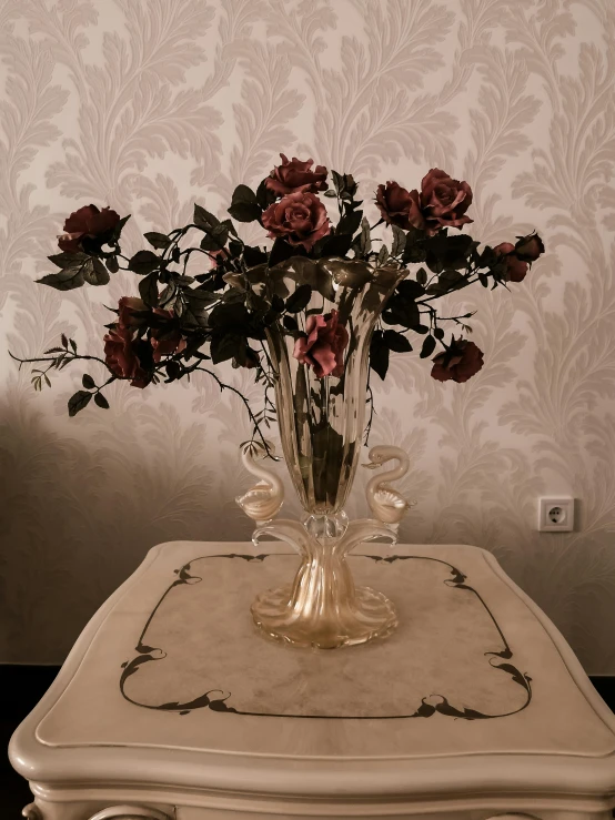 a vase filled with flowers sitting on top of a table, a colorized photo, pexels contest winner, romanticism, black roses, 👰 🏇 ❌ 🍃, 1 9 2 0 s room, red and brown color scheme