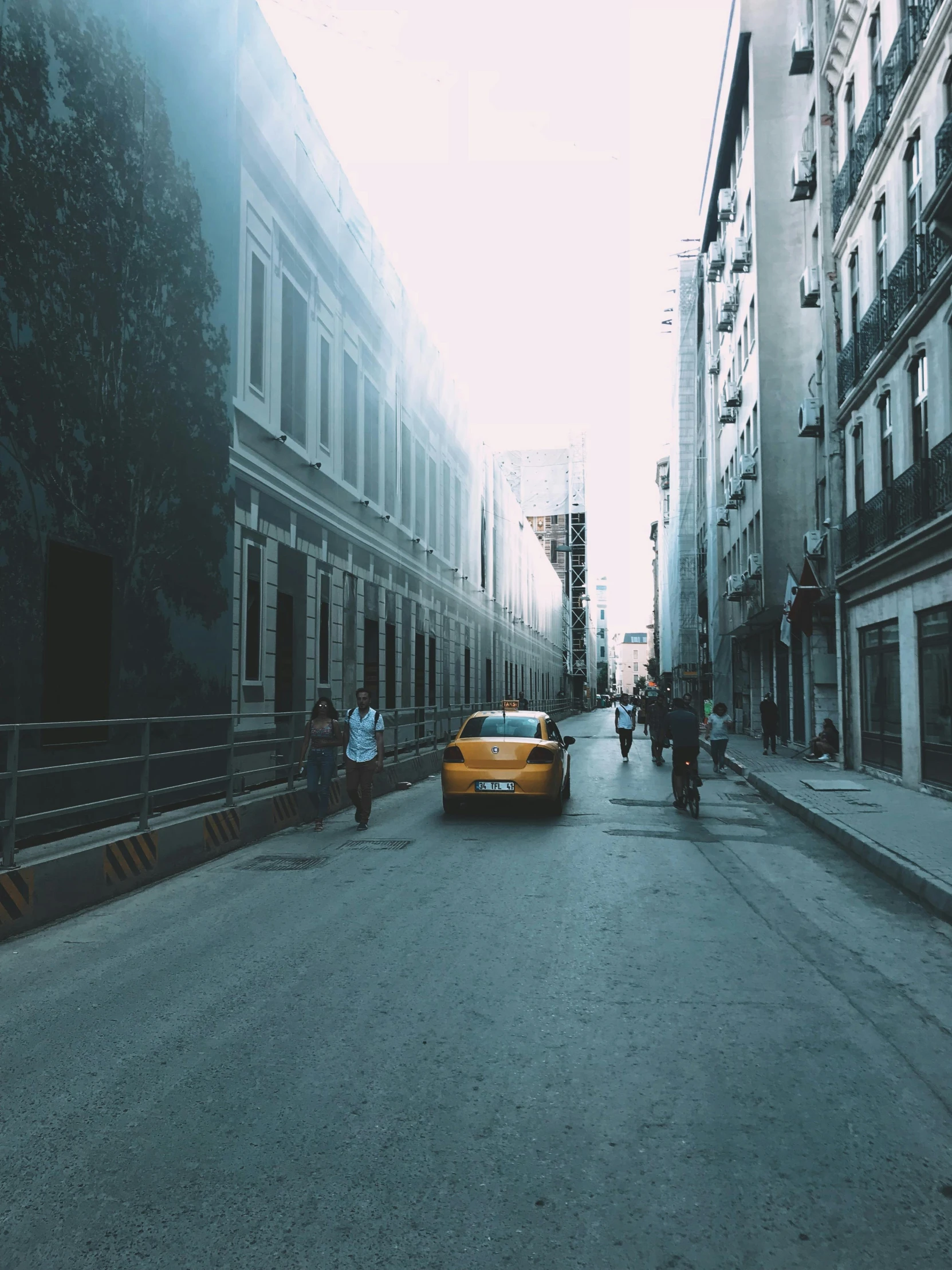 a yellow taxi driving down a street next to tall buildings, a picture, inspired by Elsa Bleda, pexels contest winner, ai weiwei and gregory crewdson, today\'s featured photograph 4k, downtown mexico, trending on vsco