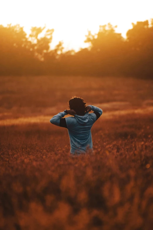 a person standing in a field at sunset, unsplash contest winner, with his back turned, distant expression, various posed, plain background