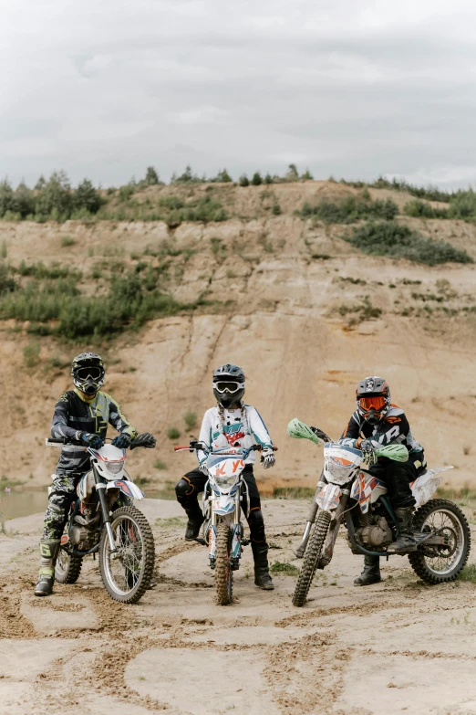 a group of people riding dirt bikes on a dirt road, dasha taran, rock quarry location, profile image, boys