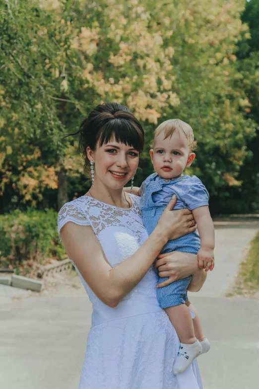 a woman in a white dress holding a baby, pexels contest winner, with short hair, nikolay, avatar image, 3 0 years old