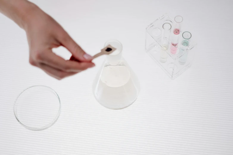 a person using a toothbrush to brush their teeth, inspired by Damien Hirst, scientific glassware, mortar and pestle, video still, on a white table