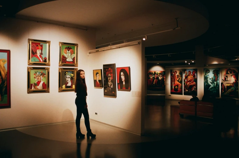 a person standing in front of a wall with paintings on it, pexels contest winner, neo-expressionism, exhibition hall lighting, caravaggesque style, angelina stroganova, foreground