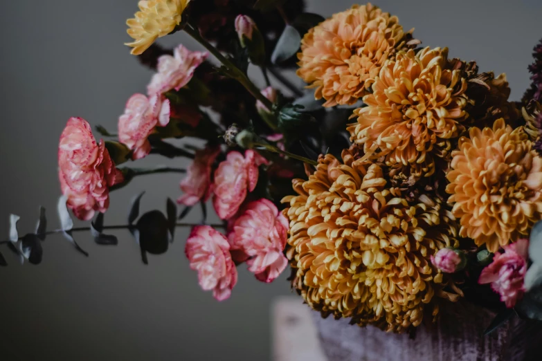 a close up of a bunch of flowers in a vase, pexels contest winner, arts and crafts movement, marigold, brown and pink color scheme, spooky autumnal colours, entertaining