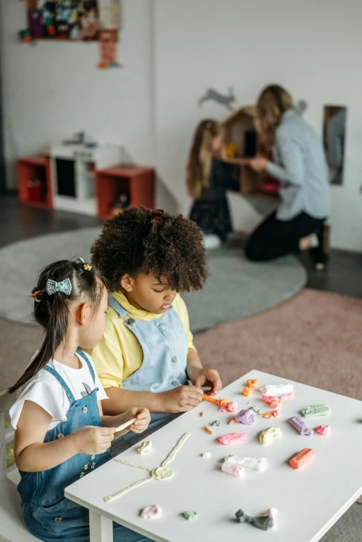 a couple of kids that are sitting at a table, pexels contest winner, arbeitsrat für kunst, activity play centre, sculpting, busy room, candy decorations