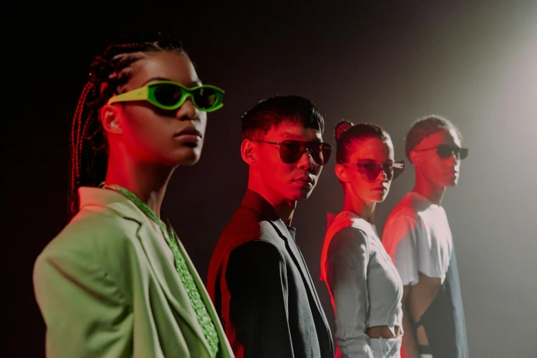 a group of people standing next to each other, trending on pexels, bauhaus, neon sunglasses!, dramatic green lighting, bella poarch, official store photo