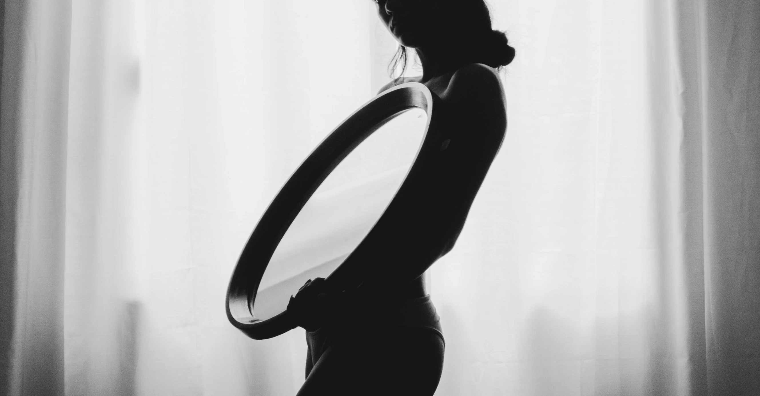 a black and white photo of a pregnant woman, by Emma Andijewska, pexels contest winner, minimalism, holding a shield, alternative reality mirrors, silhouette :7, soft rim light