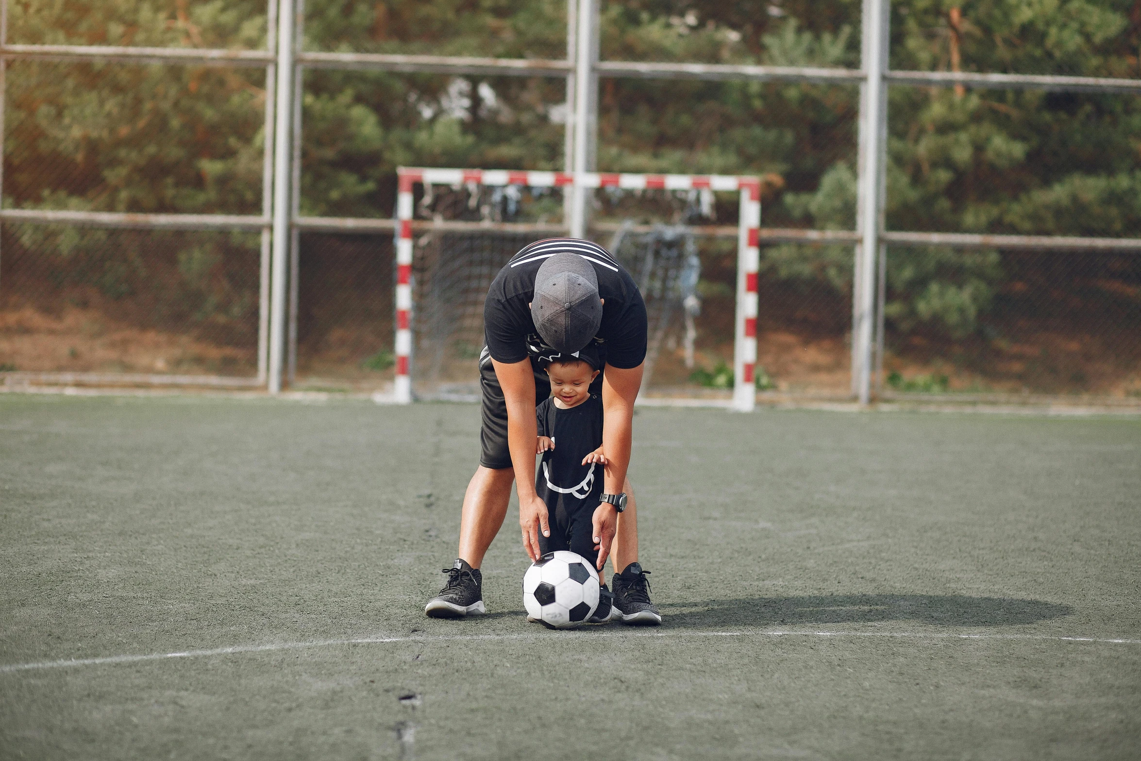 a person bending over to pick up a soccer ball, by Julia Pishtar, pexels contest winner, happening, with a kid, 15081959 21121991 01012000 4k, 4 0 years old man, head down