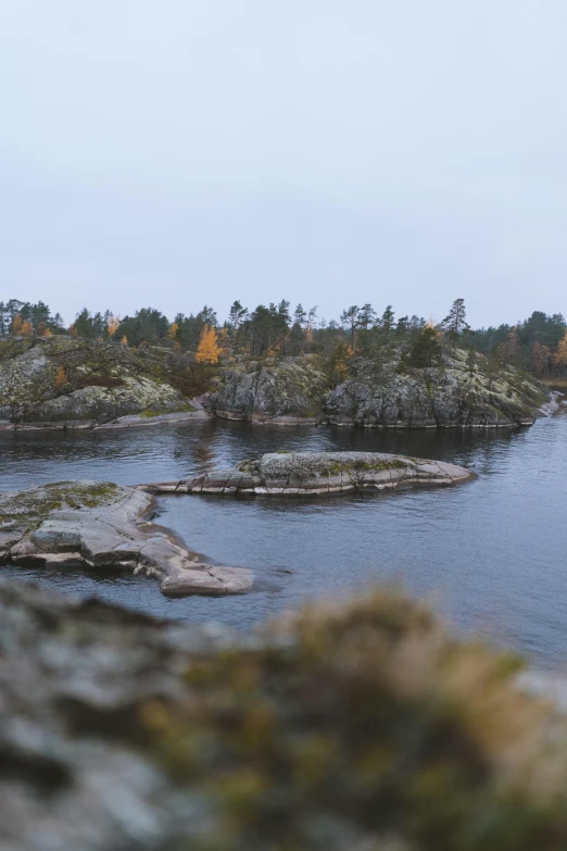 a body of water surrounded by rocks and trees, a picture, inspired by Eero Järnefelt, unsplash, les nabis, panorama view, autum, low quality photo, scattered islands