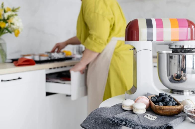 a woman standing in a kitchen preparing food, a still life, inspired by Richard Hamilton, unsplash, private press, macaron, with electric arc device, close up shot from the side, product display photograph