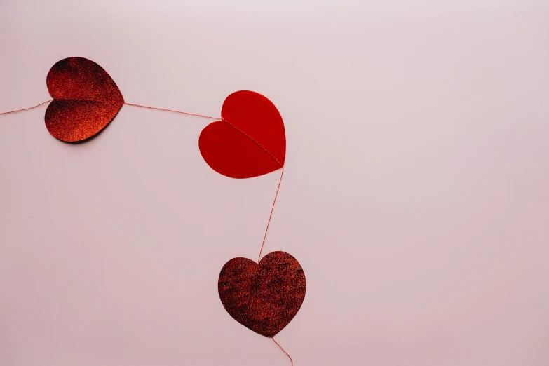 a couple of red hearts hanging from a string, pexels, profile image, foil, on high-quality paper, thumbnail
