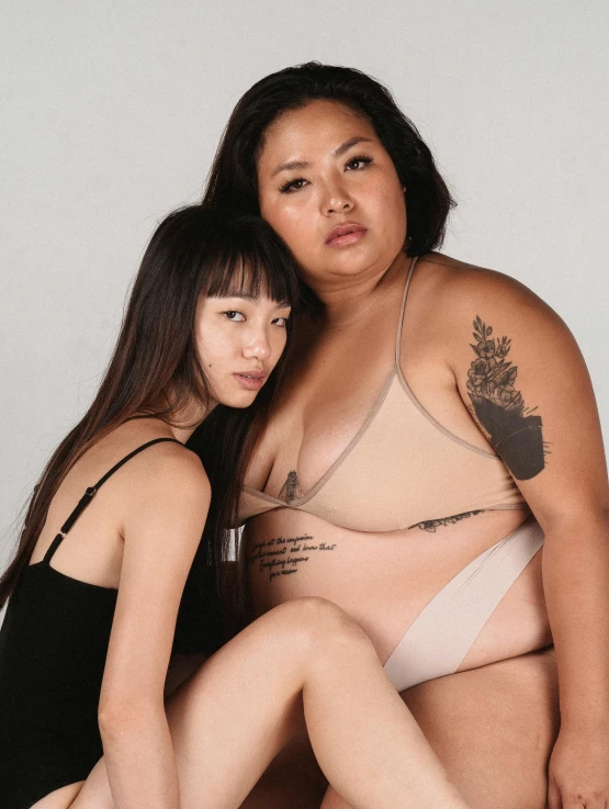 a couple of women sitting next to each other, a tattoo, inspired by Wang Duo, unsplash, thick body, underwear ad, malaysian, y2k”