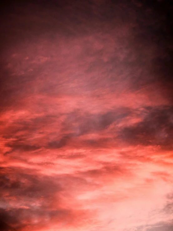 a plane flying through a cloudy sky at sunset, by James Morris, unsplash, romanticism, gradient dark red, red nebula, soft red texture, portrait photo