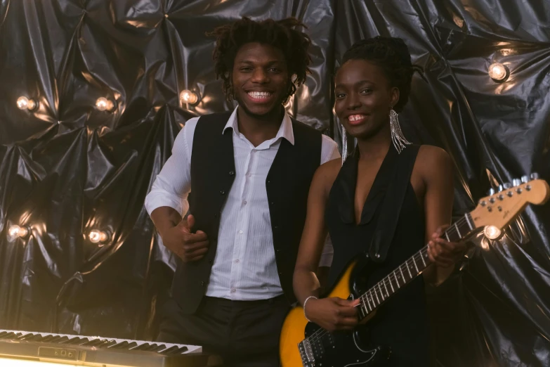 a man standing next to a woman holding a guitar, dark skin tone, keyboardist, modelling, glow