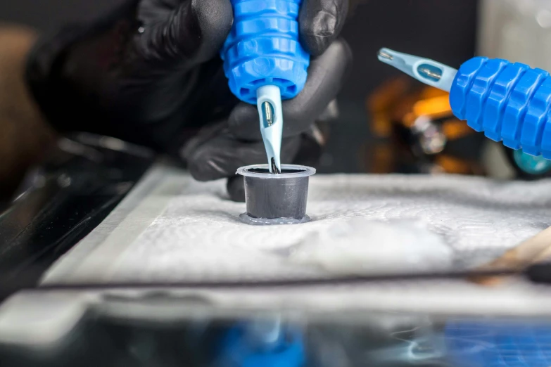a close up of a person putting something in a cup, an airbrush painting, zbrush central, pathology sample test tubes, blue ink, mechanical implants, instagram post