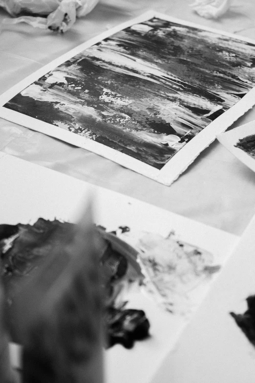 a black and white photo of art supplies on a table, a black and white photo, by Daarken, unsplash, abstract expressionism, multilayered paint, nature painting, printed on paper, detailed paintings