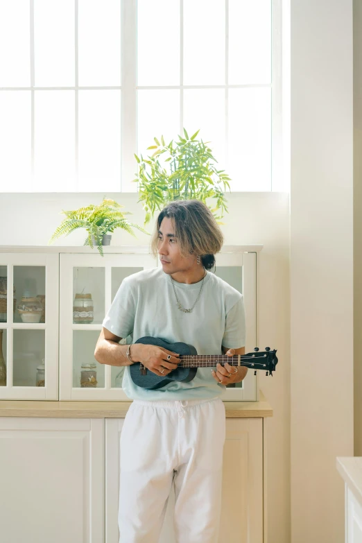 a man standing in front of a window holding a guitar, inspired by Itagaki Yoshio, unsplash, shin hanga, in the kitchen, profile image, indoor picture